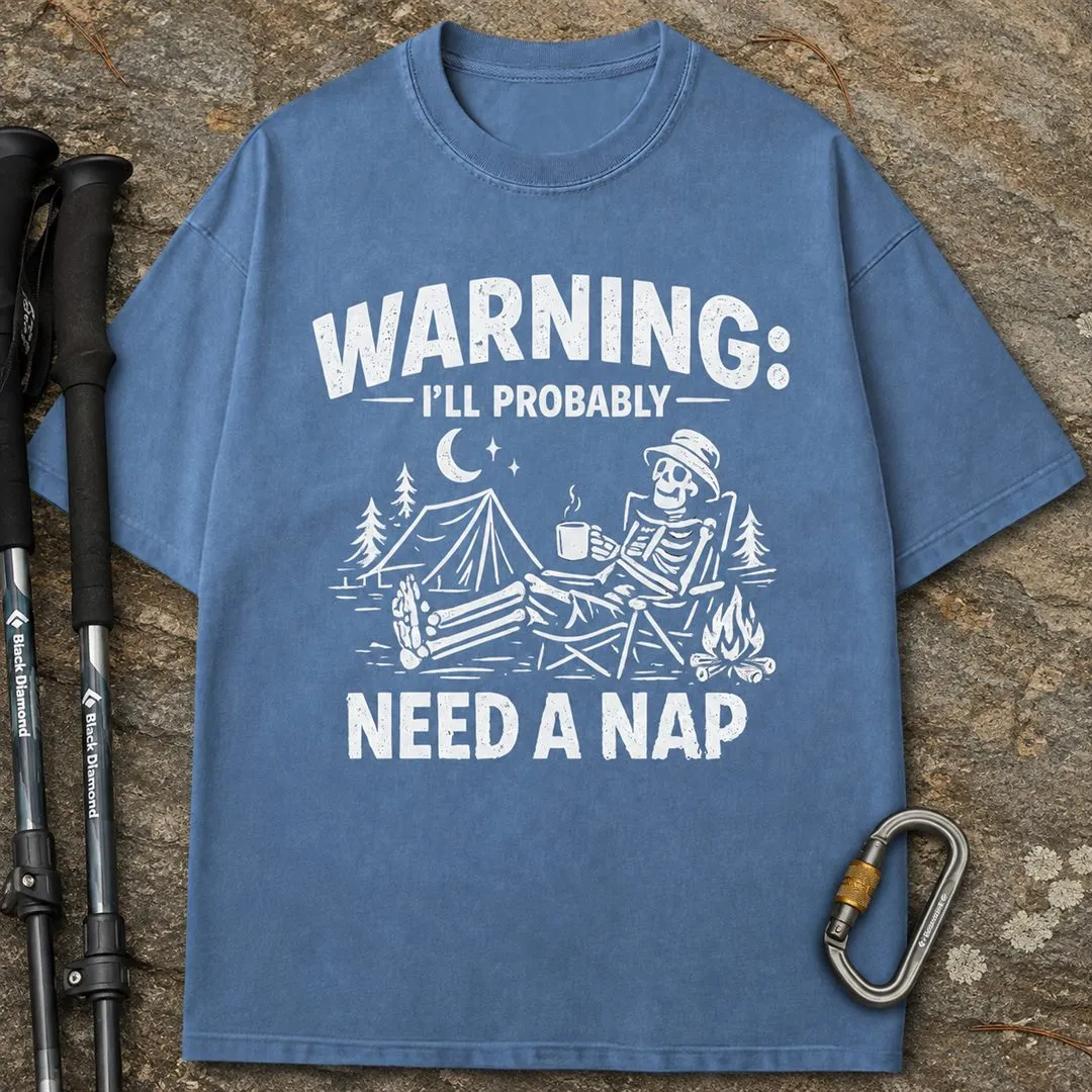 The same Need a Nap t-shirt shown as a ridge mockup on rock with trekking poles and a carabiner